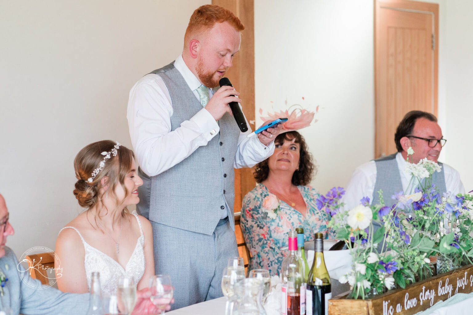 The groom delivers a heartfelt speech while standing next to the bride at their wedding reception at Dodford Manor.