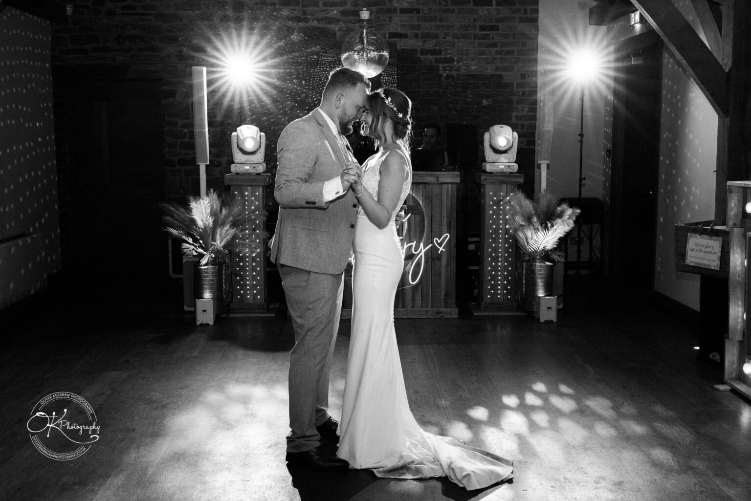 The bride and groom share a romantic first dance in a dimly lit room at Dodford Manor.