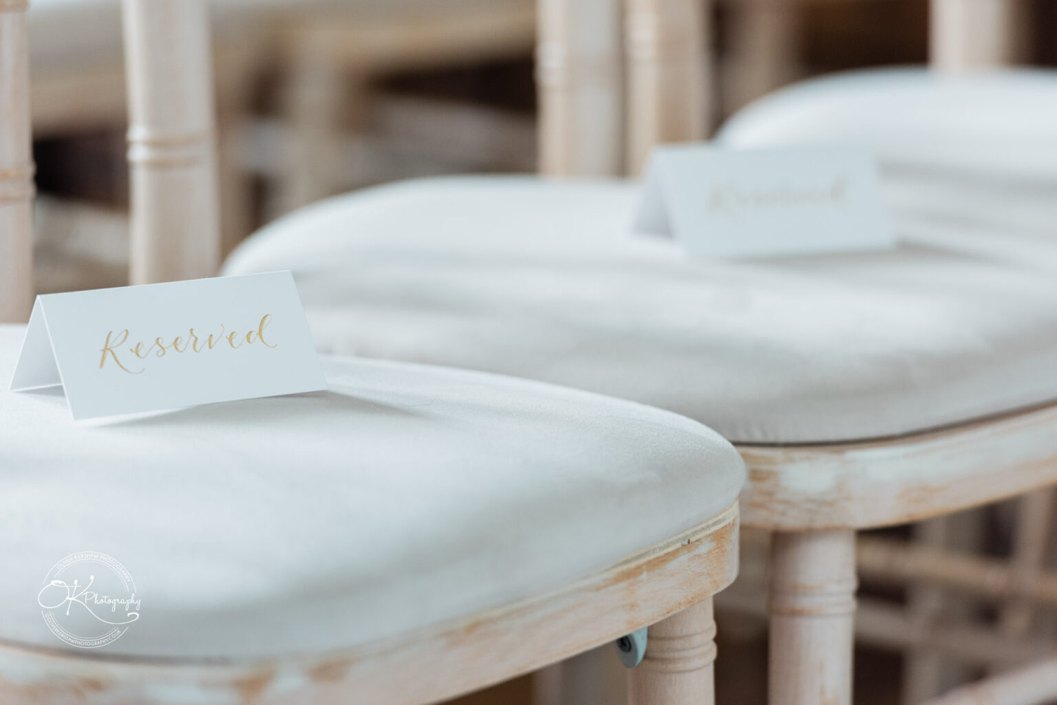 Reserved seating sign placed on a soft, cushioned chair at a wedding ceremony.