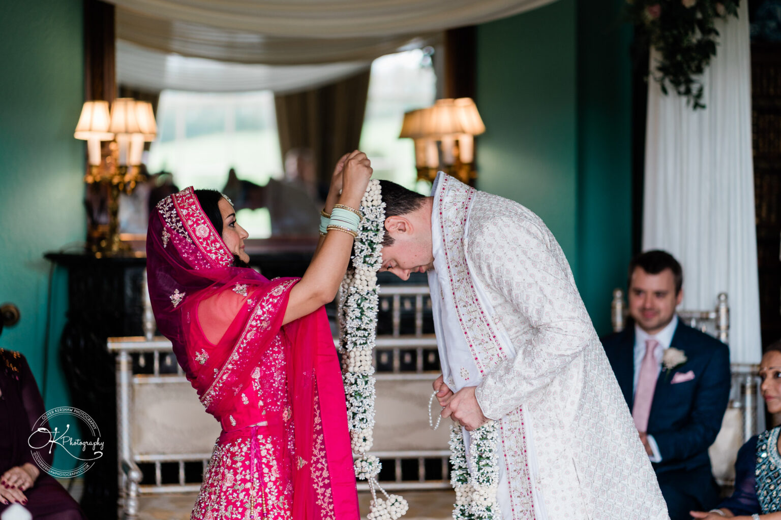 Bride placing a floral garland around the groom’s neck as part of the wedding ritual.