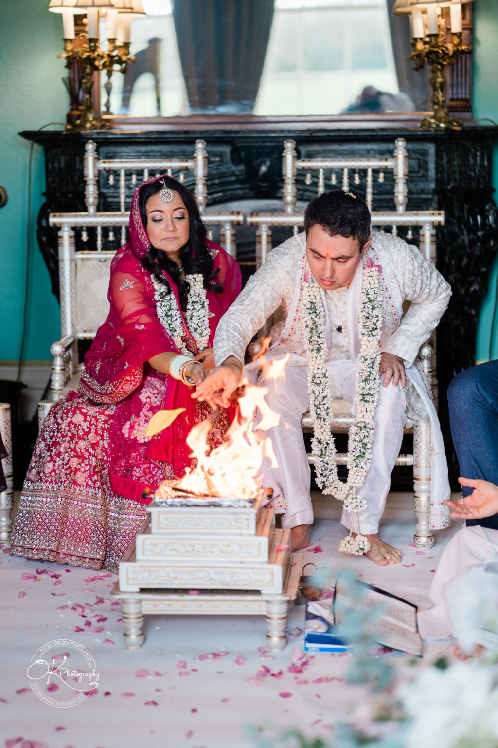 Bride and groom performing a sacred Hindu wedding ritual in traditional attire.