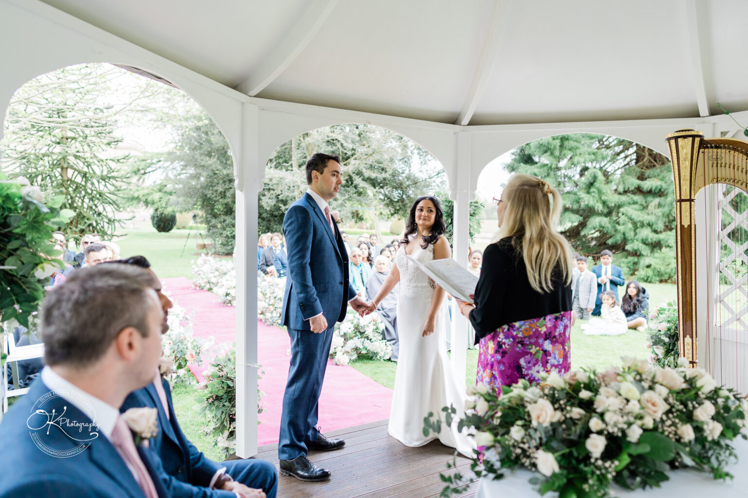 Bride and groom holding hands during the ceremony at Prestwold Hall