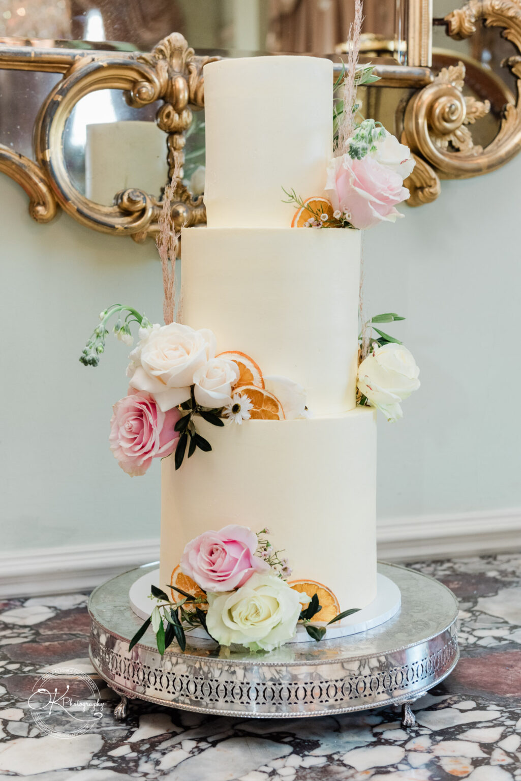 Wedding cake decorated with fresh flowers at Prestwold Hall