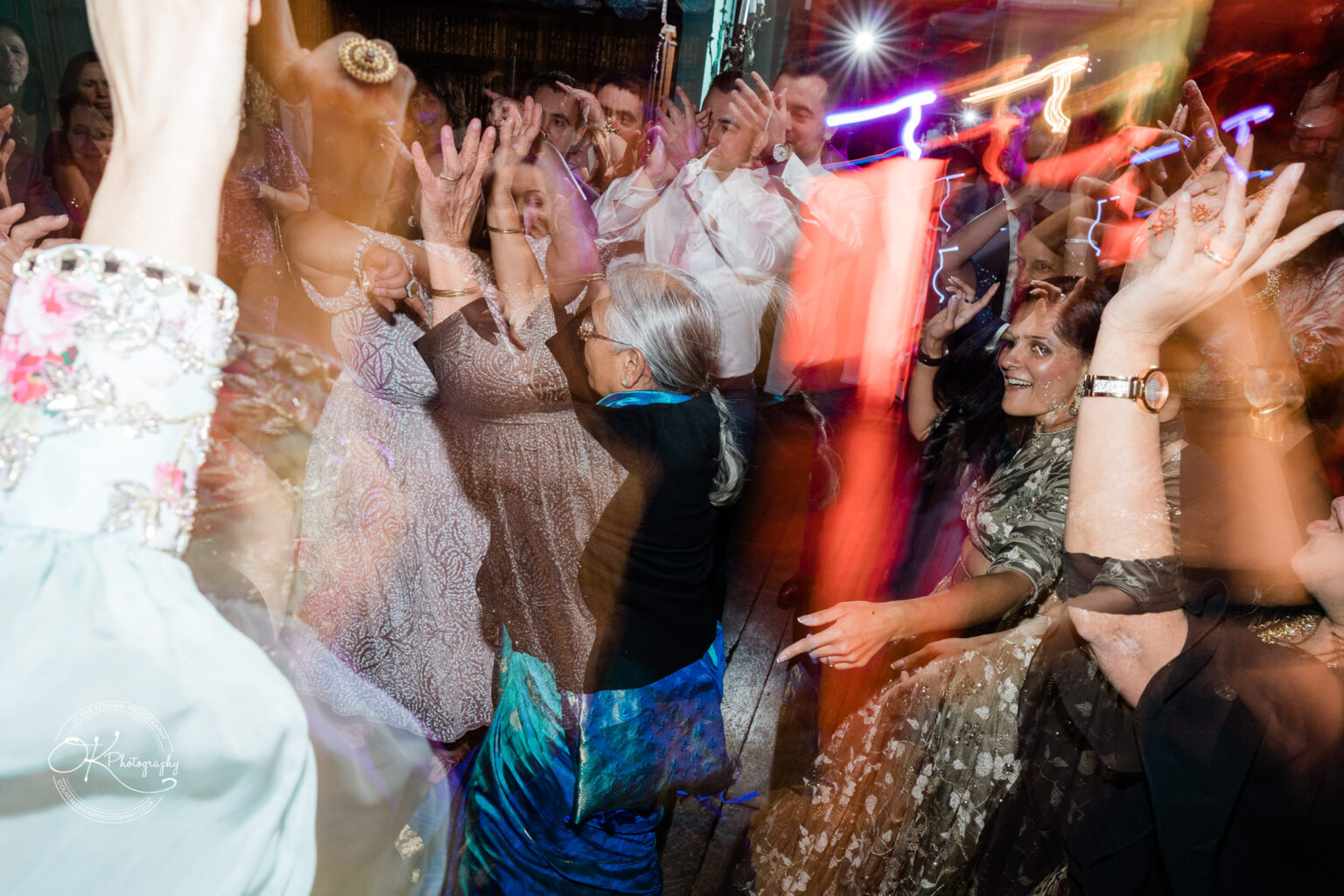 Guests dancing and celebrating at the wedding reception inside Prestwold Hall.