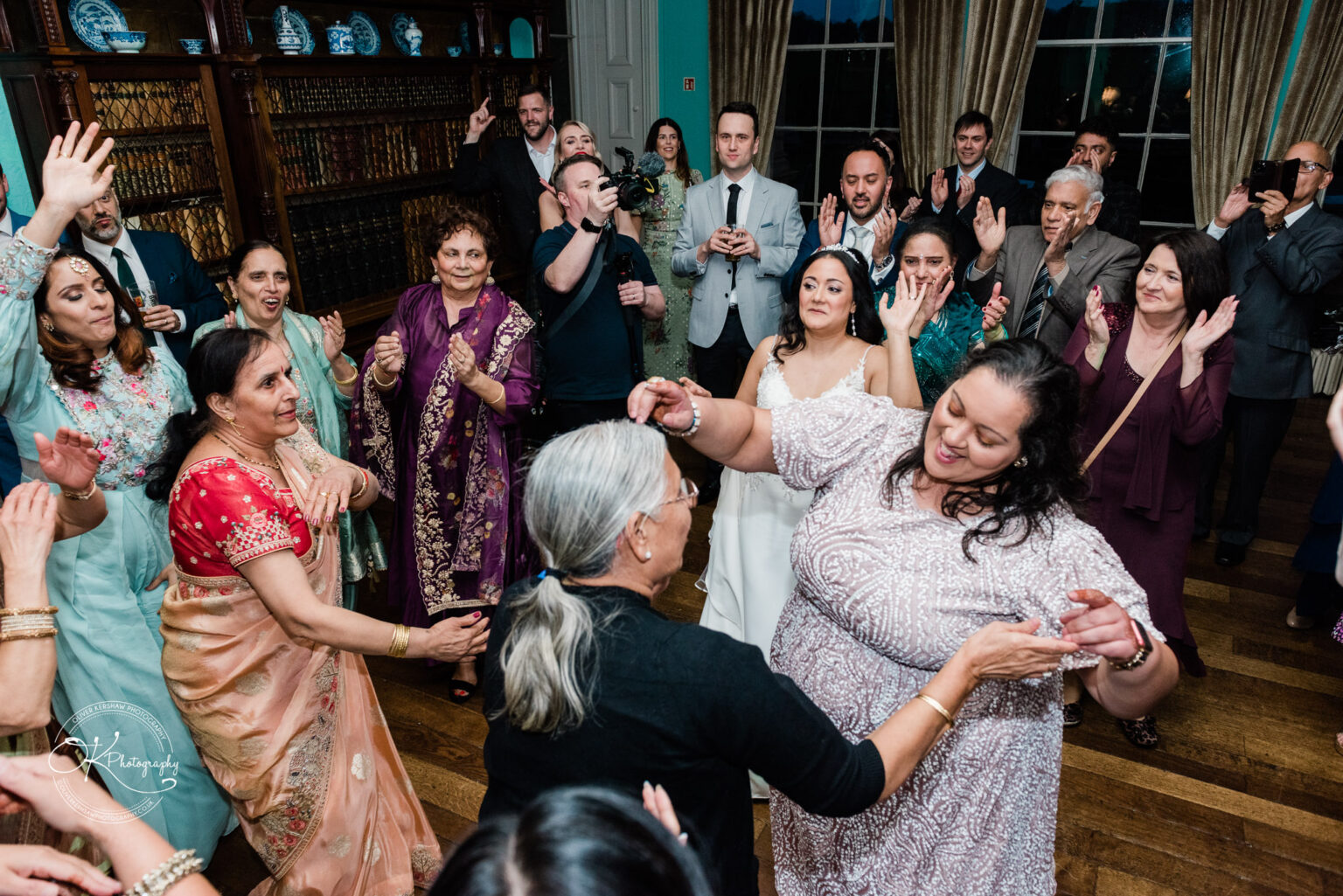 Guests dancing with the bride at the wedding reception inside Prestwold Hall.