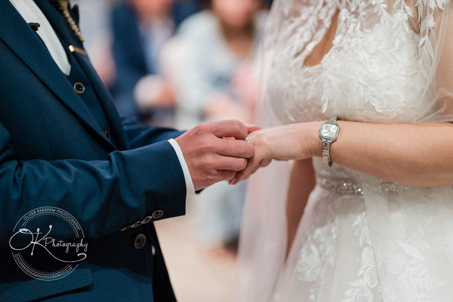 Groom placing a wedding ring on the bride's finger during a wedding ceremony.