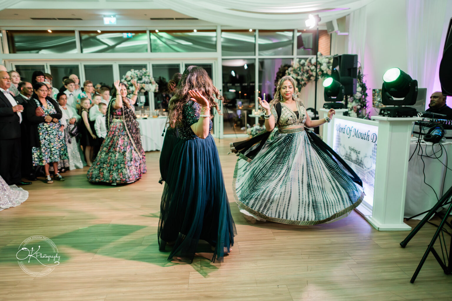 Guests dancing at a wedding reception in Winstanley House, featuring women in elegant dresses and a lively atmosphere.